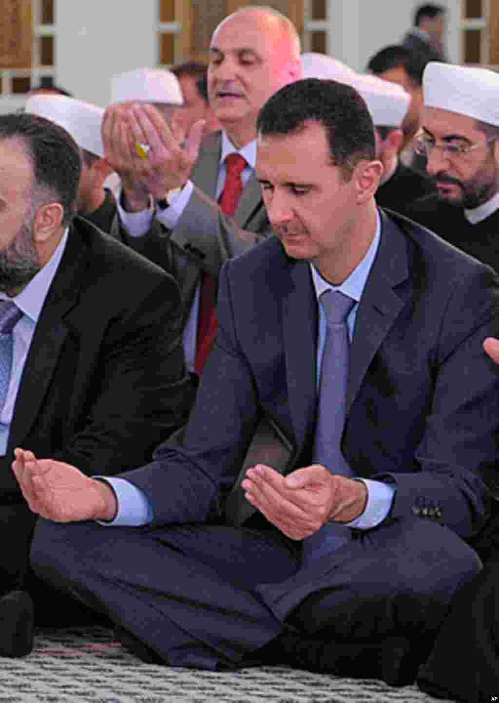 Syrian President Bashar Assad prays during the Eid al-Fitr prayer at Hafez al-Assad mosque, in Damascus, Syria, Aug. 30, 2011. AP