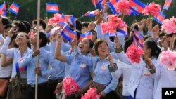 FILE - Cambodian students are seen waving national flags during Independence Day celebrations in Phnom Penh.