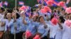 FILE - Cambodian students are seen waving national flags during Independence Day celebrations in Phnom Penh.