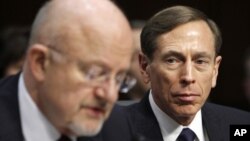 David Petraeus (derecha) escucha al director de Inteligencia Nacional, James Clapper, en otra audiencia legislativa.