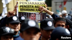 Demonstran membawa spanduk protes di luar persidangan Gubernur Jakarta Basuki "Ahok" Tjahaja Purnama dalam kasus penistaan agama di pengadilan Jakarta Utara (13/12).