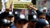 A protester holds a banner outside a court during the first day of the blasphemy trial of Jakarta's Governor Basuki Tjahaja Purnama, also known as Ahok, in Jakarta, Indonesia December 13, 2016.