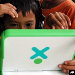A child at a Phnom Penh orphanage focuses on playing the computer game, which requires him to find food in the Cambodian countryside while avoiding on-screen landmines, June 2010