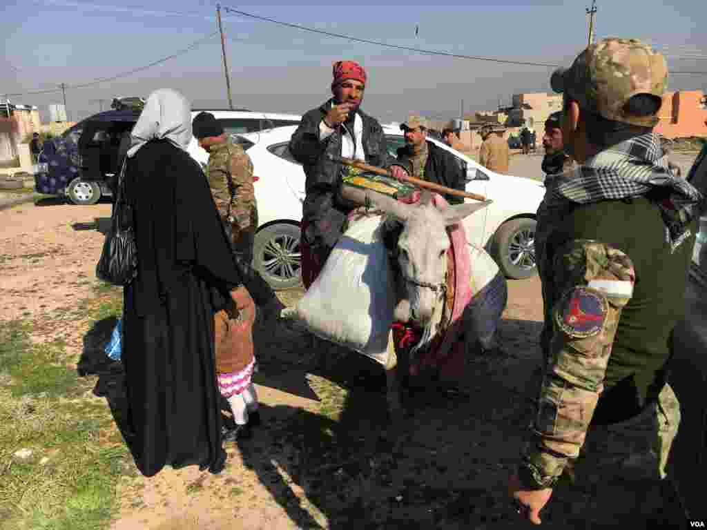 Civilians pack their belongings and flee as Islamic State is driven out of the airport in Mosul, Iraq, Feb. 23, 2017. (K. Omar/VOA)