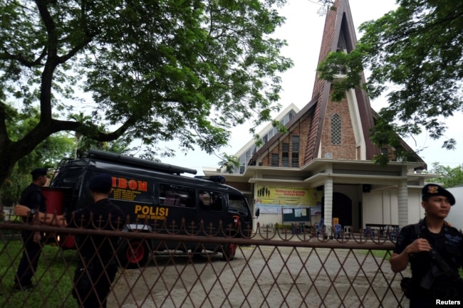 Polisi berjaga-jaga di luar Gereja Katolik St. Joseph di Medan (28/8/2016). (Foto: Antara/Irsan Mulyadi via REUTERS)