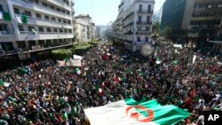 Les Algériens exhibent un drapeau national géant lors d'une manifestation à Alger, le 15 mars 2019.