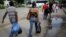 FILE - People cross to Venezuela over the Simon Bolivar bridge after shopping in Cucuta, Colombia, Dec. 1, 2016. Many Venezuelan women are selling their hair in Colombia in reaction to their country's struggling economy.  