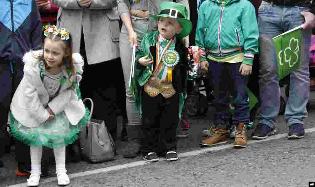 Anak-anak menunggu parade Hari St Patrick di tengah kota Belfast, Irlandia Utara, 17 Maret 2015.