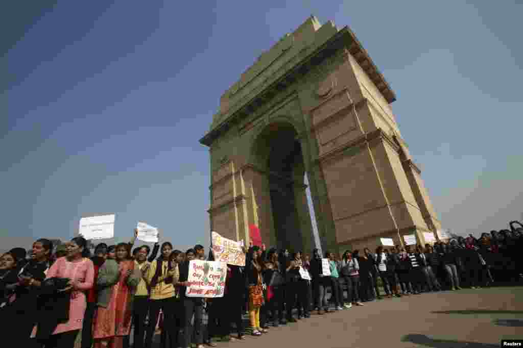 Demonstrators hold placards and shout slogans in front of India Gate as they take part in a protest rally organised by various women's organisations in New Delhi, India, December 21, 2012. 