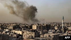 Asap mengepul di atas bangunan di kota Rafah, Jalur Gaza selatan pada 27 Maret 2024, di tengah konflik yang sedang berlangsung antara Israel dan kelompok militan Palestina Hamas.
