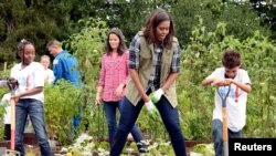 Ibu negara Michelle Obama dibantu murid-murid sekolah memanen sayuran di kebun dapur Gedung Putih (6/10). 