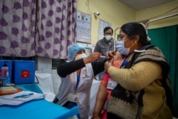 A health worker engages in a COVID-19 vaccine delivery system trial in New Delhi, India, Jan. 2, 2021.