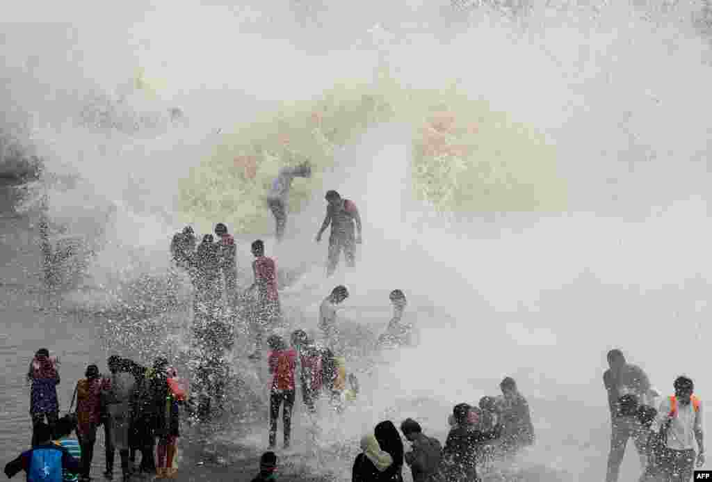 People gather by the Marine Drive seafront to be hit by breaking waves at high tide in Mumbai, India.