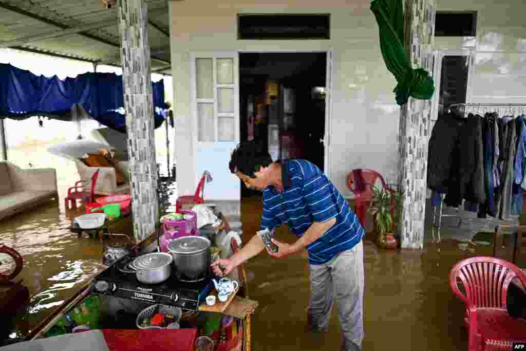 Phan Gia Quang makes tea at his flooded house in Quang Dien district in central Vietnam&#39;s Hue province.
