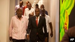 Presidential candidate Jovenel Moise, right, from the PHTK party, leaves after a press conference in Port-au-Prince, Haiti, Monday, Jan. 4, 2016.