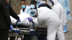 Medicinski službenici podižu vreću sa telom preminulog od koronavirusa u bolnici u Bruklinu.