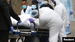 Medicinski službenici podižu vreću sa tijelom preminulog od koronavirusa u bolnici u Bruklinu