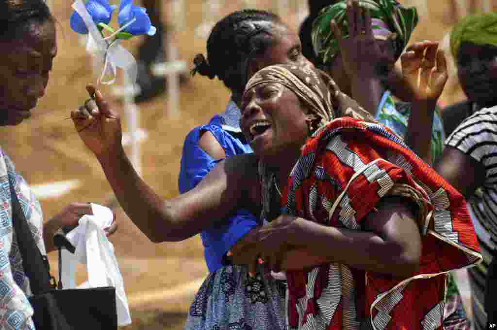 Relatives weep as they bury a loved one suspected of dying from the Ebola virus at a new graveyard on the outskirts of Monrovia, Liberia, March 11, 2015.