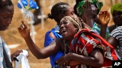 Relatives weep as they bury a loved one suspected of dying from the Ebola virus at a new graveyard on the outskirts of Monrovia, Liberia, March 11, 2015. 