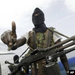 Militants wearing black masks, military fatigues and carrying Kalashnikov assault rifles and rocket-propelled grenade launchers patrol the creeks of the Niger Delta area of Nigeria, 24 Feb 2006