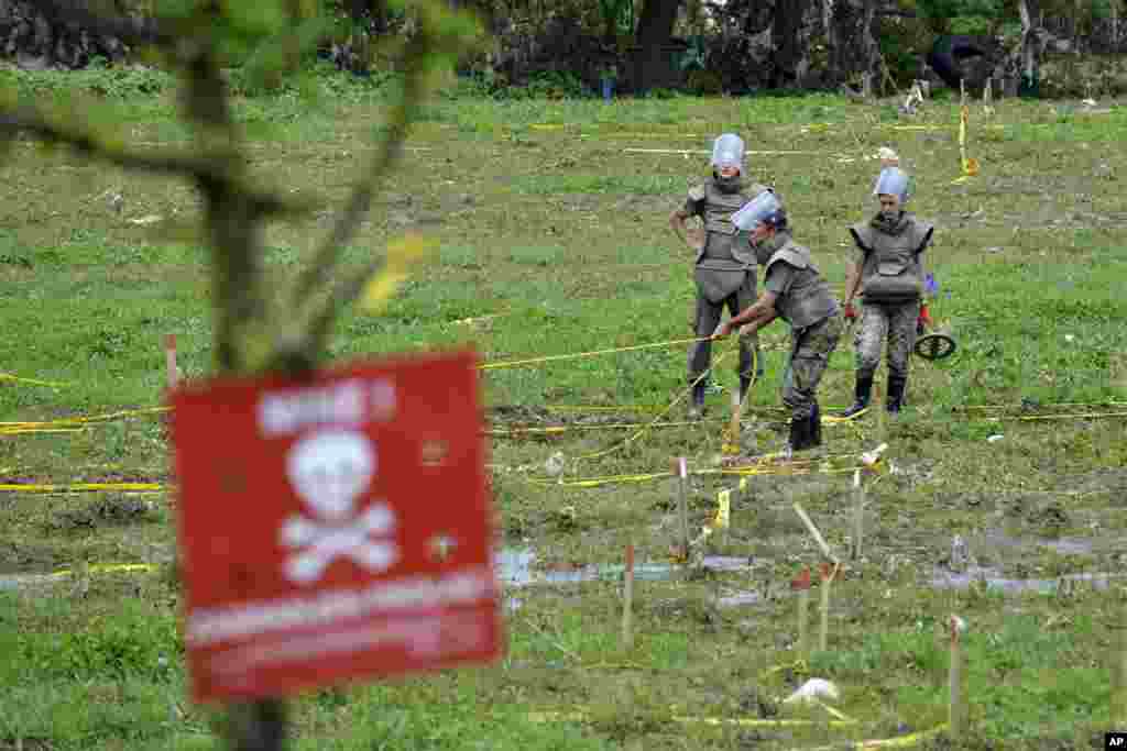Vojnici popravljaju upozorenje na opasnost od mina kod Visokog u Bosni i Hercegovini. 20. maj, 2014.