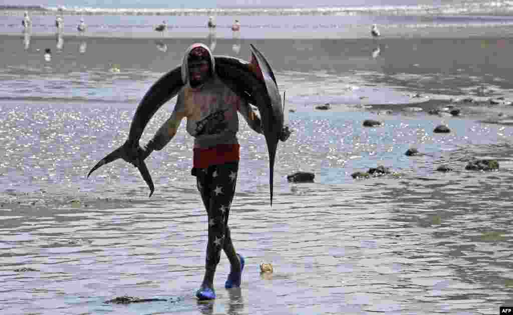 A fisherman carries a sailfish to the market in Aden after catching it off the coast of Yemen's southern port city.