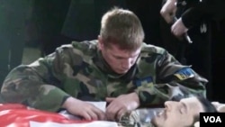 ფოტოზე: უკრაინის არმიის ოფიცერი დაღუპულ ქართველ თანამებრძოლს ეთხოვება