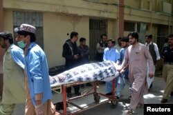 FILE - Hospital workers push a stretcher carrying the body of a policeman who was one of the policemen shot dead in Quetta, Pakistan, July 13, 2017.