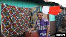 John Sunday, 23-year-old student and first-time voter, poses for a picture in the Makoko shanty town built on stilts in a lagoon in Lagos, Feb. 4 , 2019.