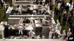 Chefs prepare food during the final of the "Bocuse d'Or" (Golden Bocuse) trophy, in Lyon, central France, Wednesday, Jan. 30, 2019. (AP Photo/Laurent Cipriani)