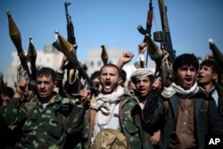 FILE - In this Nov. 24, 2016, photo, tribesmen loyal to Houthi rebels hold their weapons as they chant slogans during a gathering to mobilize more fighters into battlefronts in several Yemeni cities, in Sanaa, Yemen.