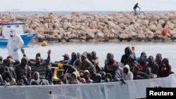 FILE - After more than 300 migrants died Friday trying to cross the Mediterranean, other migrants arrived by boat at the Sicilian harbor of Pozzallo, Italy, Feb.15, 2015. 