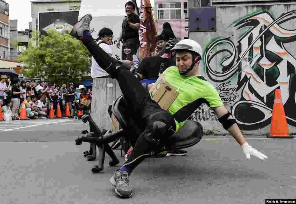 A reveler falls from the chair as he participates in the office chair racing in Tainan city, southern Taiwan.