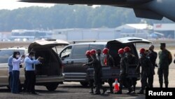 Mexican soldiers unload one of 15 coffins of Guatemalan migrants who died in a truck crash in southern Mexico, in Guatemala City, Guatemala, Dec. 30, 2021. 