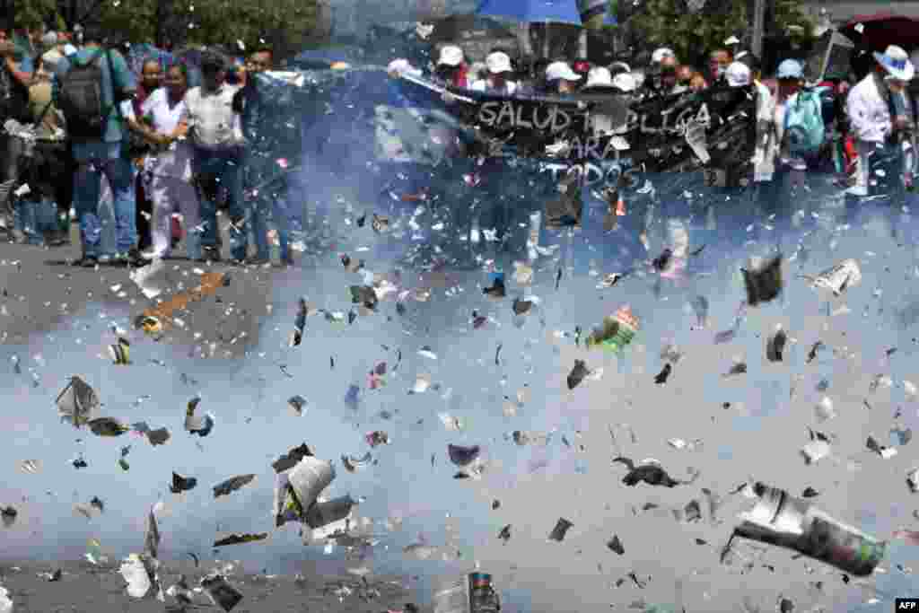 High school teachers, medical doctors and university students celebrate with firecrackers as they march toward the Congress building, demostrating against education and health care reforms, in Tegucigalpa, Honduras, April 30, 2019.