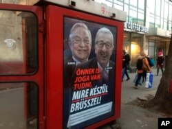 A phone box displays a billboards showing Hungarian-American financier George Soros and EU Commission President Jean-Claude Juncker above the caption “You have a right to know what Brussels is preparing to do!," on Vaci Avenue in Budapest, Hungary, Feb. 19, 2019.