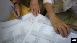 Voters inspect their ballots at a polling station in Zagreb, Croatia, Sept. 11, 2016. 