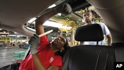 FILE - Assembly worker Julaynne Trusel works a on a 2012 Chevrolet Volt at the General Motors Hamtramck Assembly plant in Hamtramck, Michigan.