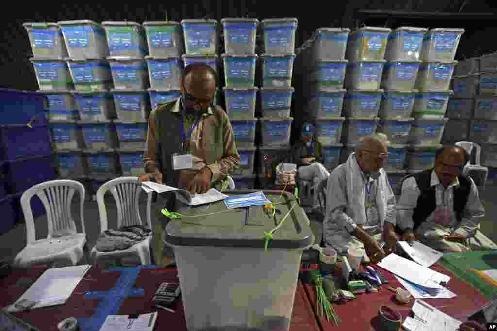 Afghan election commission workers sort ballots for an audit of the presidential run-off, in Kabul, Aug. 25, 2014.