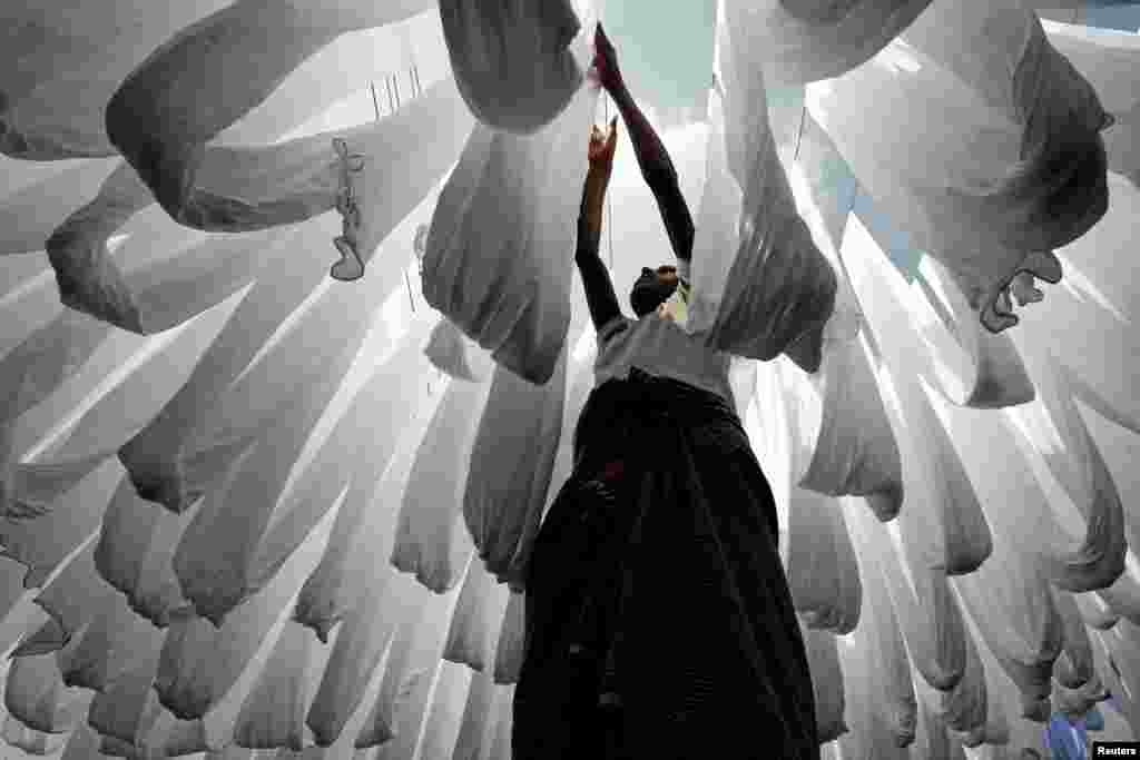 A dye factory worker dries fabric in Narayanganj near Dhaka, Bangladesh.