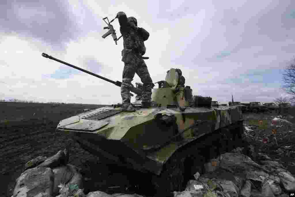 A Ukrainian soldier stands on an armored vehicle at a military camp near the village of Michurino, Ukraine.