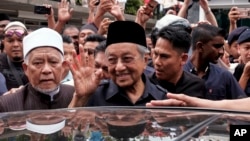 馬來西亞總理馬哈蒂爾（中）星期五离開吉隆坡國家清真寺時向民眾招手致意。（2018年5月11日）