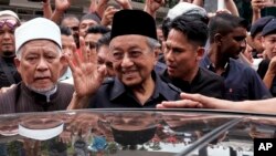 PM Malaysia Mahathir Mohamad (tengah) melambai kepada pendukungnya setelah menunaikan shalat Jumat di Masjid Nasional, Kuala Lumpur, Malaysia (11/5).