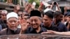 FILE - Malaysian Prime Minister Mahathir Mohamad, center, waves to crowds leaving National Mosque after Friday prayers in Kuala Lumpur, Malaysia, May 11, 2018. 