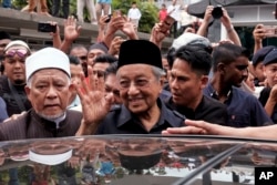 FILE - Malaysian Prime Minister Mahathir Mohamad waves to crowds leaving National Mosque after performing Friday prayers in Kuala Lumpur, Malaysia, May 11, 2018.