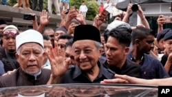 :马来西亚总理马哈蒂尔2018年5月11日在首都吉隆坡的国家清真寺参加完周五礼拜之后向众人挥手致意。