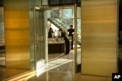 FILE - Employees stand inside a Tiffany & Co. store at a shopping mall in Beijing, Nov. 29, 2018.