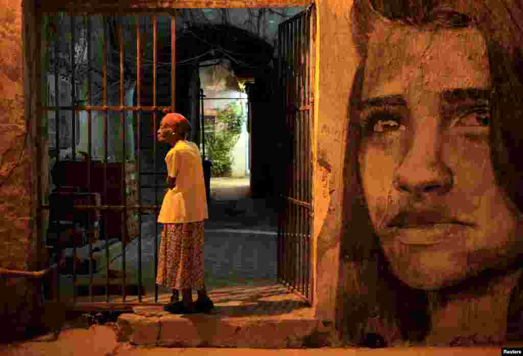 An elderly woman stands outside her house in Havana, Cuba, Dec. 31, 2015.