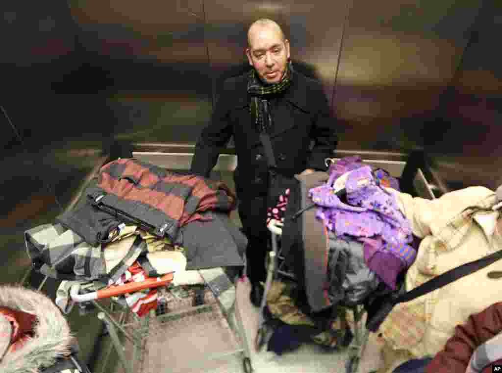 Manuel Diaz Escobar, seorang turis dari Mexico City, naik lift dengan barang hasil belanjaannya di Kmart, New York (28/11). (AP/Julio Cortez)