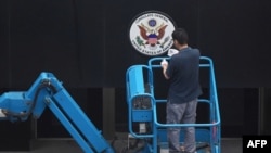 一名工人正在拆除美國駐成都總領館入口處的領館標誌
